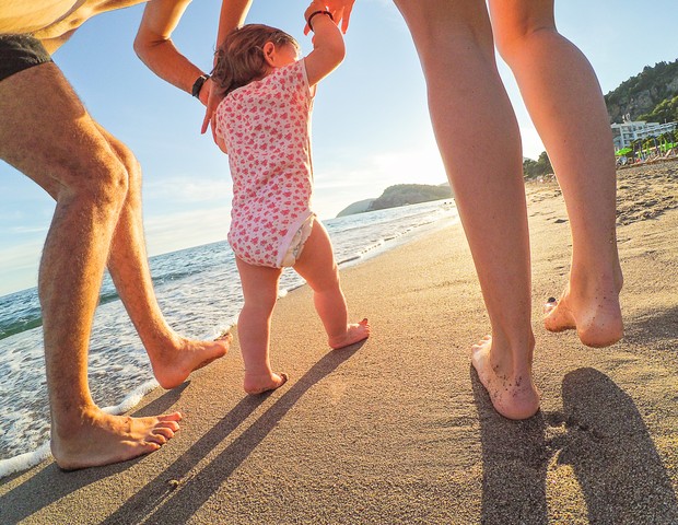 Criança de mãos dadas na praia (Foto: ThinkStock)