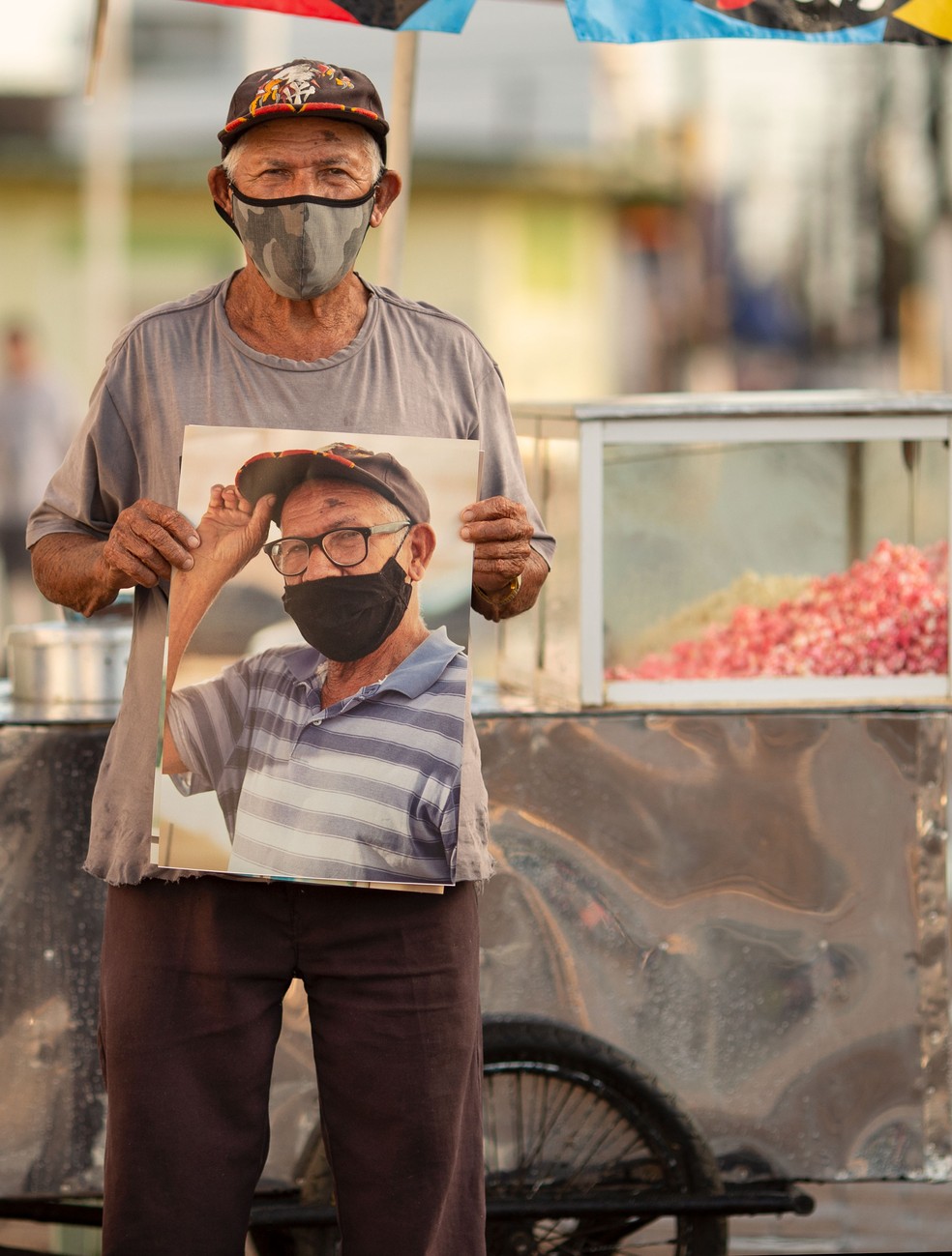 Vendedor ambulante Manuel com fotografia do ensaio em mãos — Foto: Marcelo Xavier