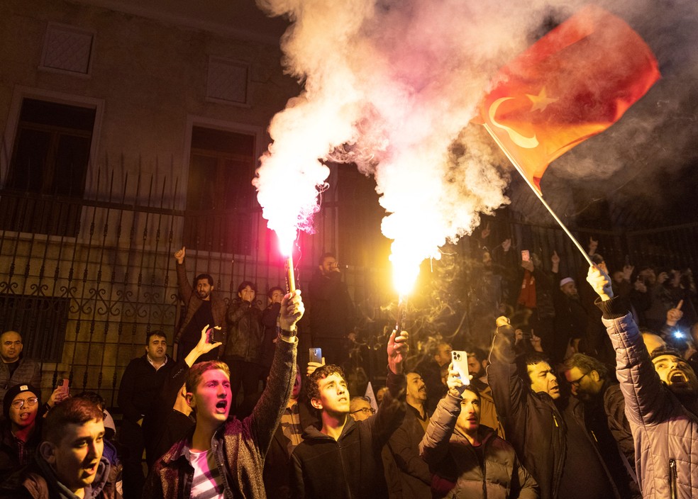 Protestantes se manifestam com sinalizadores e bandeira da Turquia nas ruas de Estocolmo — Foto: Umit Bektas/REUTERS