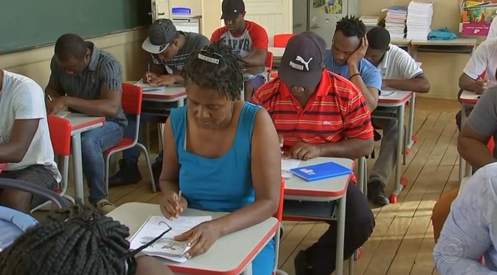 Grupo de Haitianos se reúne para ter aulas de língua portuguesa em Pereiras — Foto: Reprodução/TV TEM
