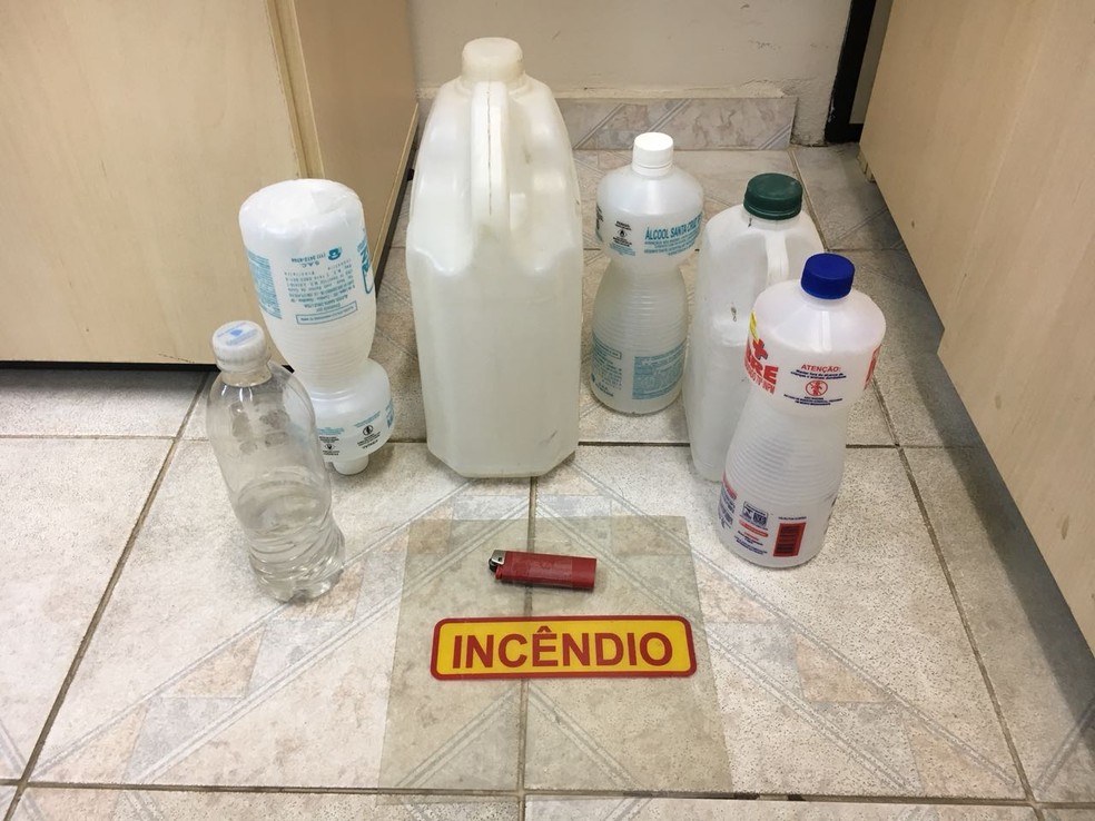 Material apreendido com suspeito inclui garrafas com álcool, vestígios de gasolina, isqueiro e uma placa de incêndio  (Foto: Emily Costa/G1 RR)