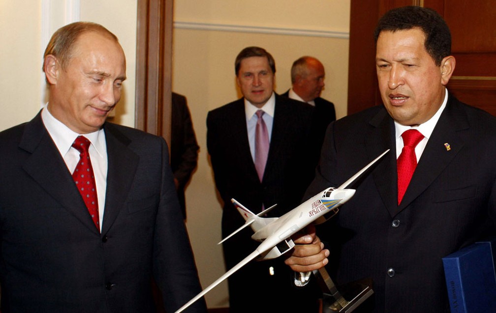 Hugo Chávez segura uma réplica de um avião russo durante encontro com o então primeiro-ministro do país Vladimir Putin em outubro de 2008. — Foto: Palácio Miraflores/ The New York Times