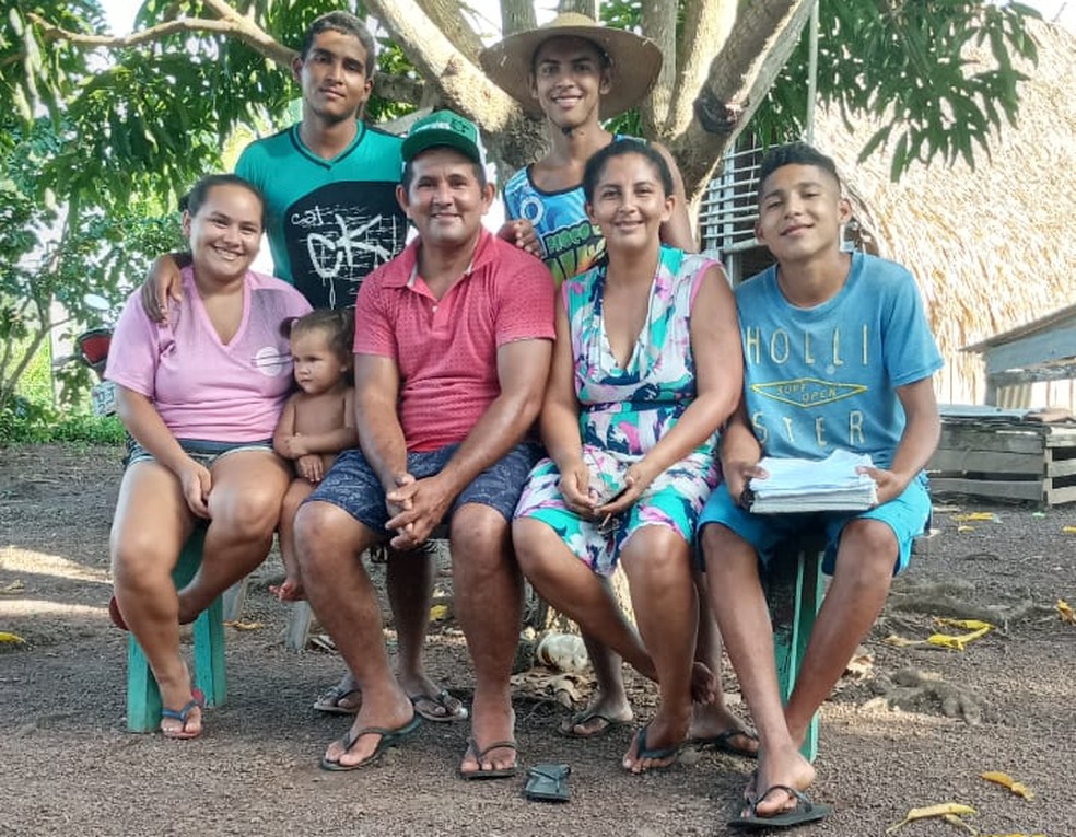 Família de Artur embaixo da mangueira, que teve uma 'sala de aula' adaptada para aulas remotas — Foto: Lúcia Ribeiro/Arquivo Pessoal