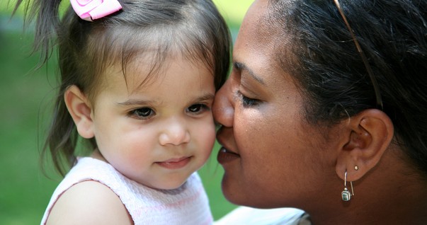 Mãe com a filha adotiva no colo (Foto: Shutterstock)
