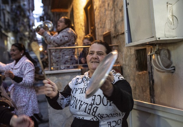 Italianas se juntam na frante das casas para cantar com pessoas nos terraços em Nápoli: quarentena criou novas formas de expressões culturais (Foto: Ivan Romano/Getty Images)