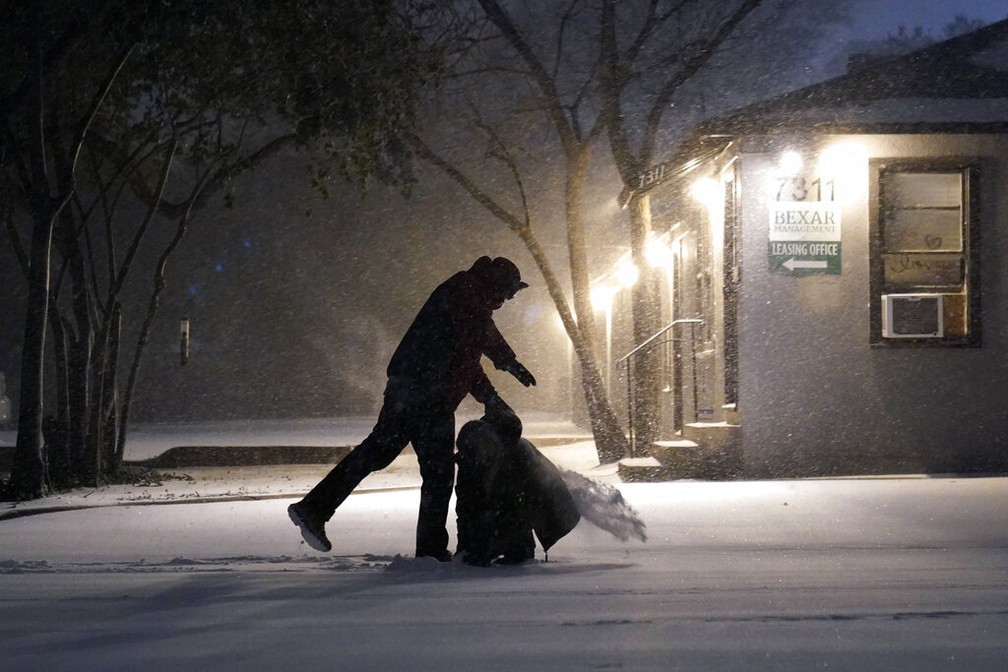 Pessoas brincam na neve durante nevasca em San Antonio, Texas (EUA), no domingo (14) — Foto: Eric Gay/AP Photo