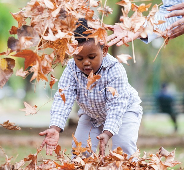 Menino brincando com folhas no outono (Foto: Getty Images)