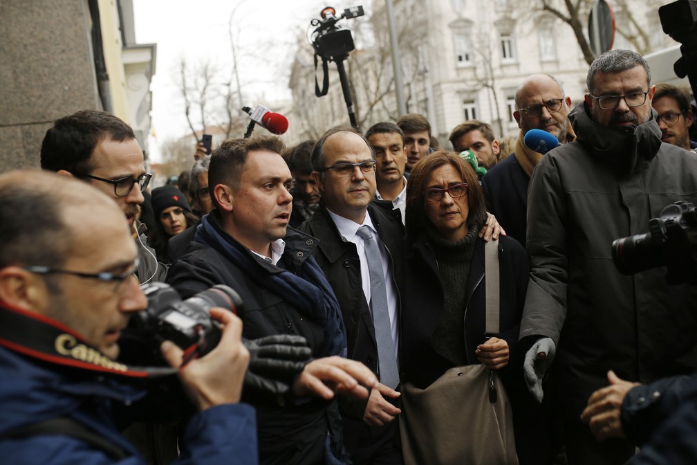 Independentista catalão Jordi Turull é cercado por jornalistas e ao lado de sua mulher ao sair da Suprema Corte nesta sexta-feira (23) durante intervalo em audiência (Foto: Francisco Seco/AP Photo)