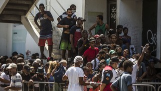 Pessoas se aglomeram à espera de uma refeição distribuída pela Fundação Leão XIIIAgência O Globo