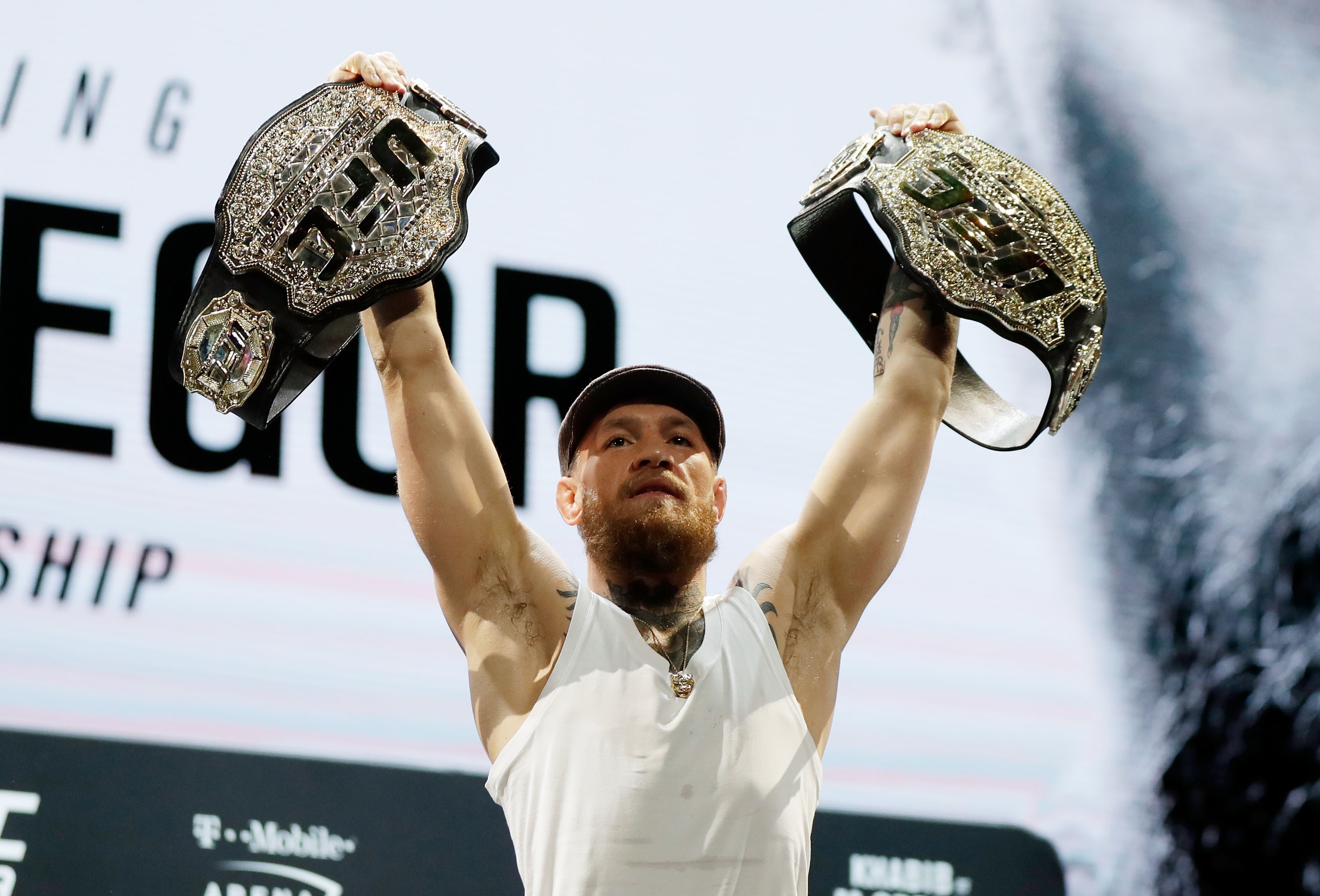 Conor McGregor exibe seus cinturões, embora ele nunca tenha defendido nenhum dos dois (Foto: Getty Images/ Isaac Brekken)