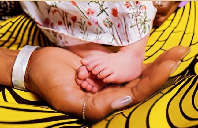 Naomi segurando o pé da filha (Foto: Reprodução: Daily Mail )