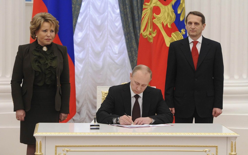 21/3 - O presidente russo, Vladimir Putin (centro), assina documentos oficializando o processo de incorporação da região da Crimeia ao país após referendo em que a ampla maioria optou pela separação da Ucrânia — Foto: Mikhail Klimentyev/RIA Novosti/Kremlin/Reuters