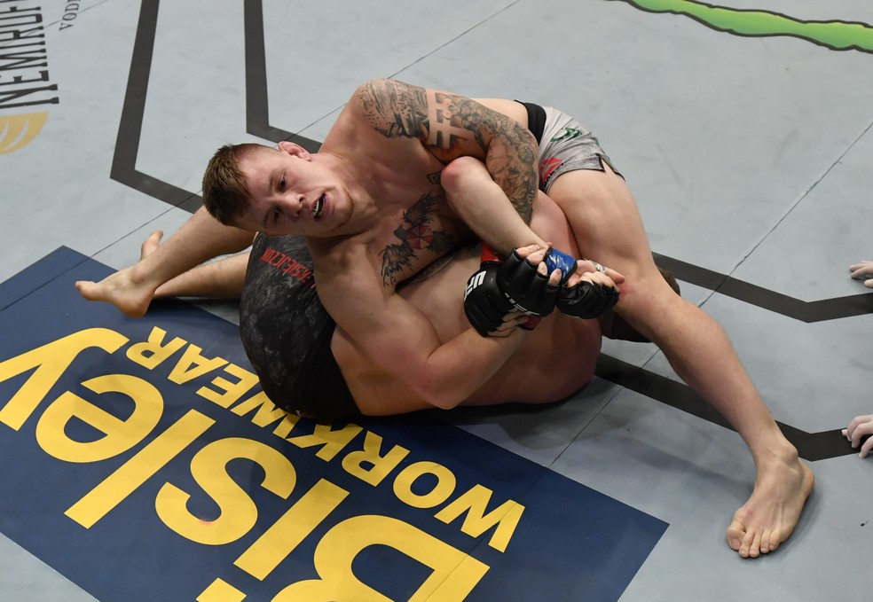 Jimmy Crute entorta o braço de Michal Oleksiejczuk com a kimura no UFC Auckland — Foto: Getty Images