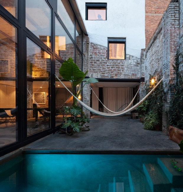 Ao lado do living, um pátio com redes de descanso e piscina traz verde e luz natural ao interior (Foto:  Sandra Pereznieto/ Deezen/ Reprodução)