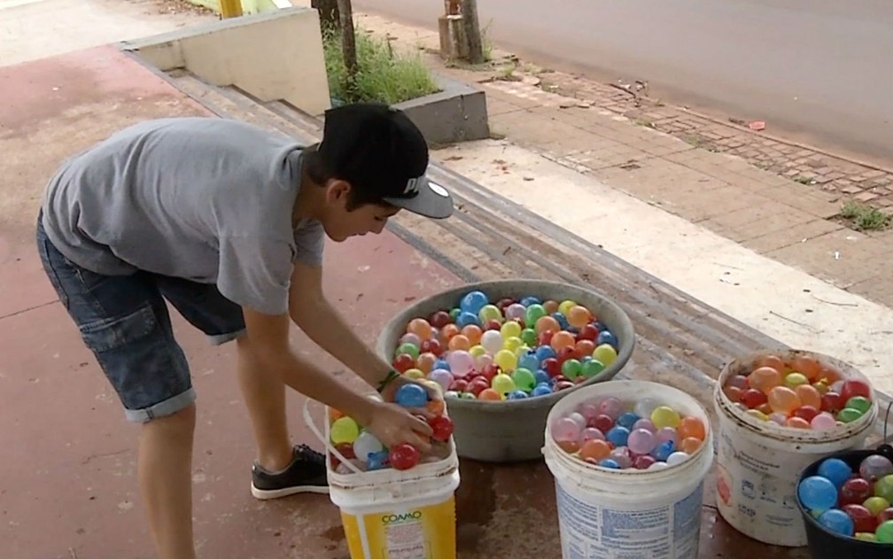 Participante da guerra de bexigas de água em Ponta Porã (MS) se 'arma' para confronto (Foto: Reprodução/TV Morena)