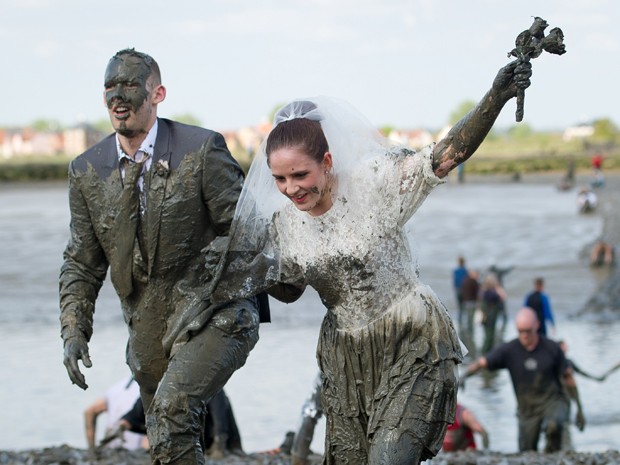 Casal de 'noivos' na anual corrida na lama em Maldon, na Inglaterra, neste domingo (5) (Foto: Leon Neal/AFP)