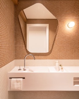 Com a reforma comandada pelo Voilà Studio, o banheiro da suíte ganhou revestimentos com tons de rosa, dando continuidade ao restante do projeto