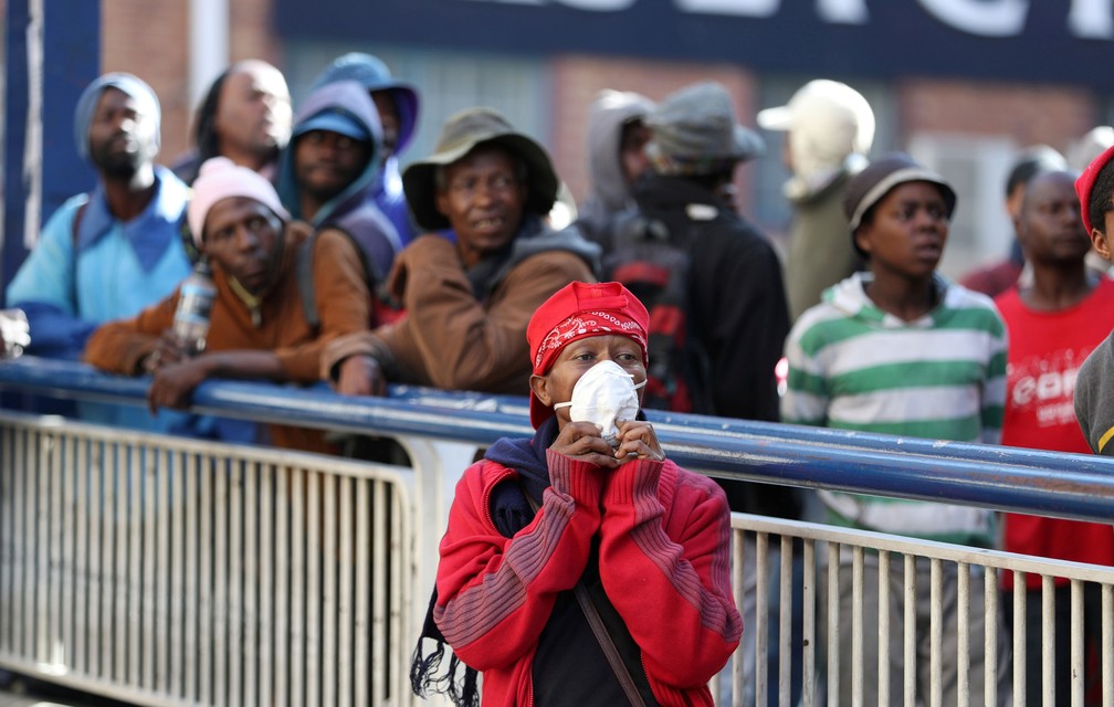 Sem-teto observam agente de segurança da África do Sul que fazem patrulha nas ruas de Joanesburgo nesta sexta-feira (27), primeiro dia de um bloqueio nacional de 21 dias para tentar conter o surto de Covid-19 — Foto:  Siphiwe Sibeko/ Reuters 