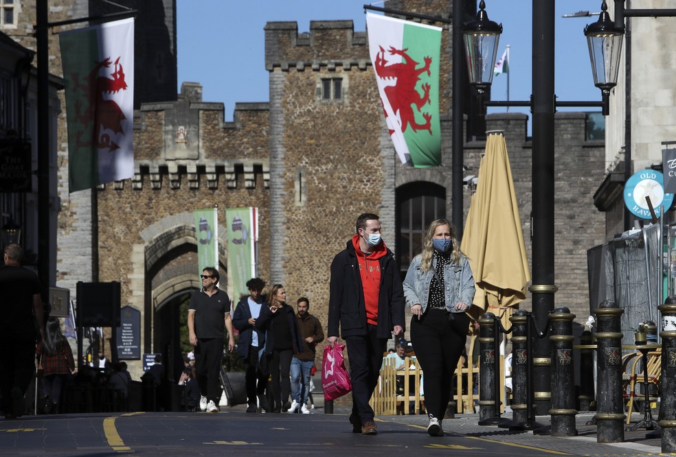 Casal anda de máscaras para proteção contra a Covid-19 em Cardiff, sul do País de Gales, no dia 27 de setembro. — Foto: Geoff Caddick / AFP