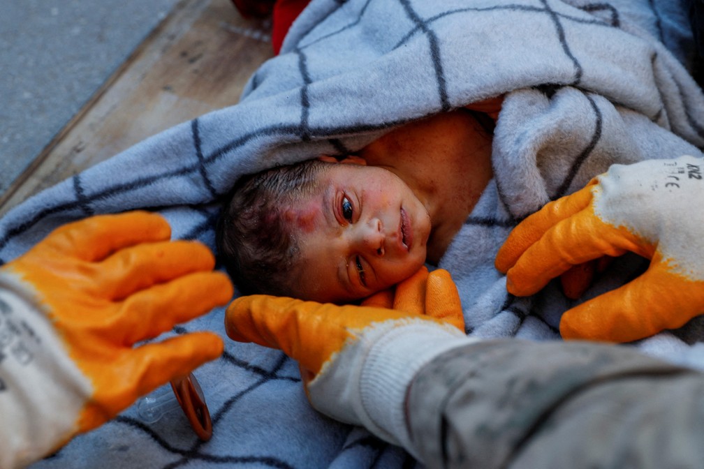 Bebê recém-nascido socorrido em Hatay, na Turquia, recebe cuidados da equipe de resgate — Foto: Kemal Aslan/REUTERS
