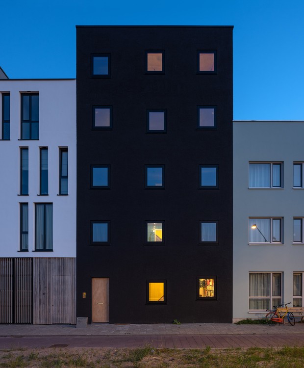 A fachada preta e com janelas pequenas oferece privacidade para os dormitórios e também evita que os ruídos da rua passem para o interior (Foto:  Ossip van Duivenbode/ Dezeen)