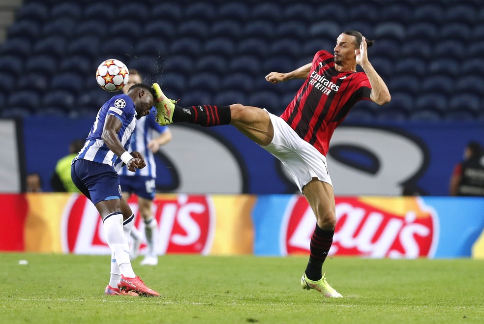 Ibrahimovic acerta a cabeça de Mbemba com o pé em Porto x Milan — Foto: REUTERS/Pedro Nunes
