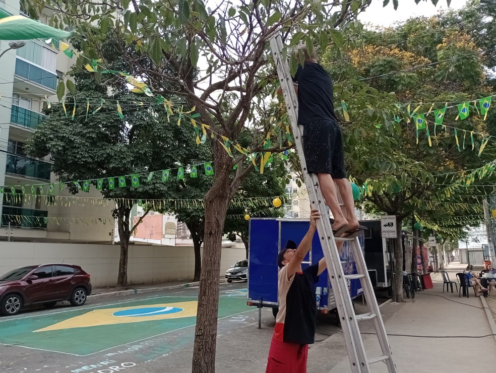 A decoração continuou durante a tarde quando um grupo de amigos e parentes continuaram a fazer e pendurar as tirinhas na praça. — Foto: Mikaella Mozer