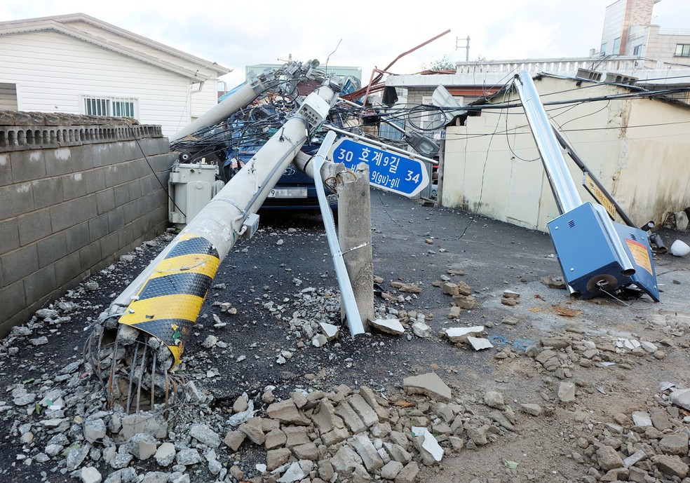 Um poste de eletricidade é visto caído uma rua danificada pelo tufão Maysak em Ulsan, na Coreia do Sul, nesta quinta-feira (3) — Foto: Yonhap via Reuters