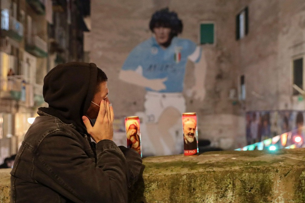 Torcedor acende velas por Maradona em Nápoles, onde o craque argentino fez história nos anos 90 — Foto: Salvatore Laporta/AP Photo
