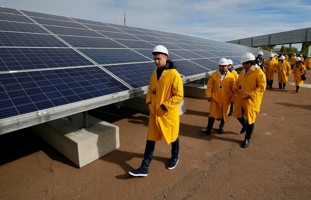 visitantes passam por painéis solares em uma usina de energia solar construída no local do pior desastre nuclear do mundo, Chernobyl, Ucrânia — Foto: REUTERS/Gleb Garanich