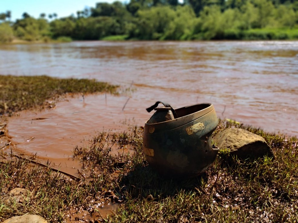 Ás margens do rio, capacete que desceu com a enxurrada — Foto: Paula Paiva Paulo