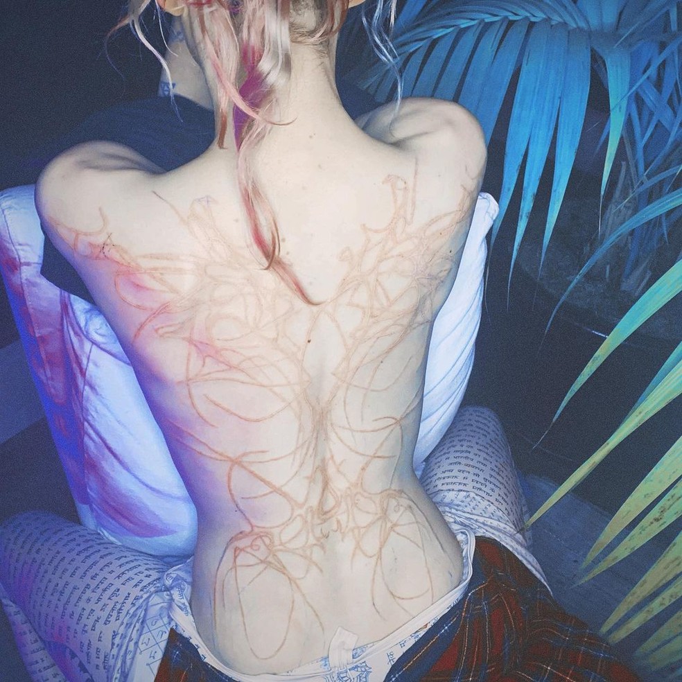 Cantora Grimes tatua 'cicatrizes alienígenas' nas costas — Foto: Reprodução/Instagram