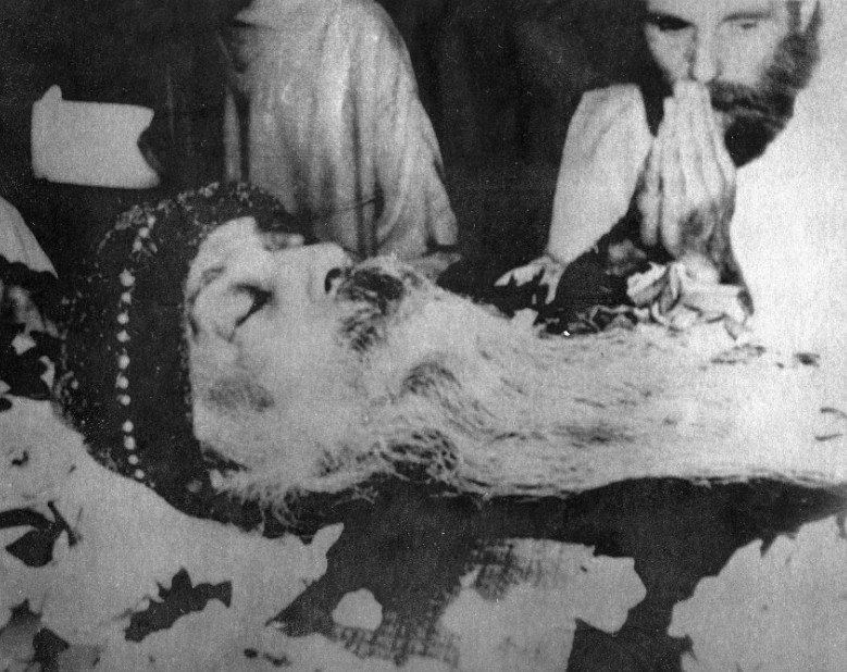 Discípulo ora ao lado do corpo de Rajneesh em velório, no dia 20 de janeiro de 1990