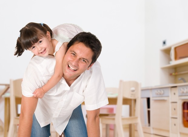 Pai e filha brincando dentro de casa (Foto: Shutterstock)