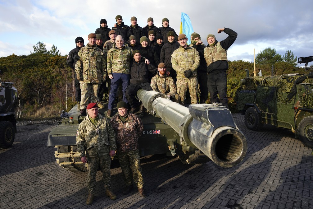 O secretário de Defesa da Grã-Bretanha, Ben Wallace, posa com soldados ucranianos durante visita a base militar do Exército Britânico onde eles estão treinando em tanques Challenger 2 — Foto: Ben Birchall/Pool via AP
