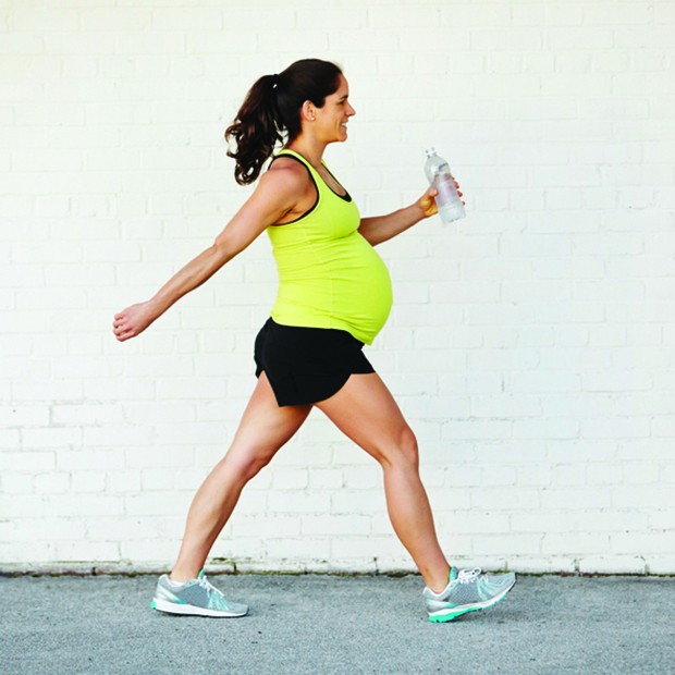 Young pregnant  woman exercising by walking carrying an water bottle. (Foto: Getty Images)