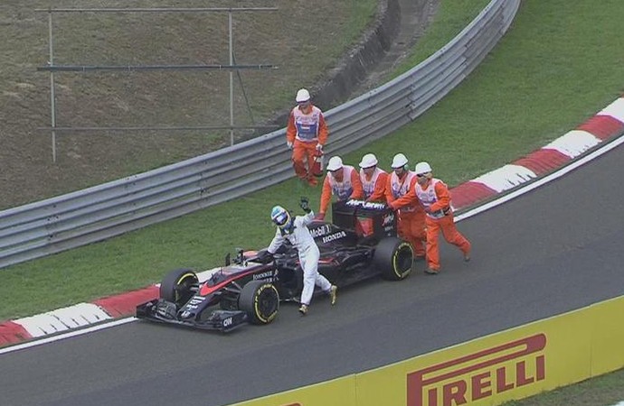 Fernando Alonso empurra McLaren e acena para os fãs ao mesmo tempo após ter problema em treino classificatório para o GP da Hungria (Foto: Reprodução)