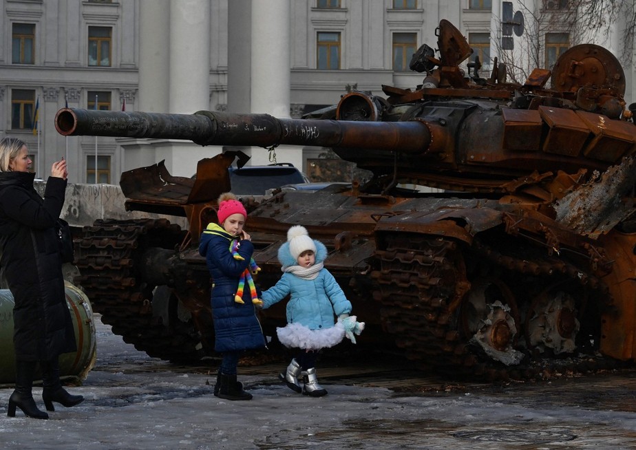 Uma mulher fotografa crianças em frente à carcaça de um tanque em uma exposição ao ar livre de equipamentos russos destruídos em Kiev: capital pode voltar a ser atacada por terra