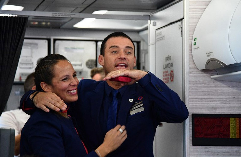 Comissários de bordo Paula Podest e Carlos Ciufffardi sorriem após Papa Francisco celebrar casamento durante voo no Chile  (Foto: Vincenzo Pinto / AFP)