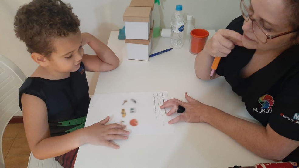 Foto: Adriana (psicóloga) e Gustavo, de 6 anos, em terapia com metodologia MIG, que trabalha atenção, concentração, foco e regras — Foto: Cedida