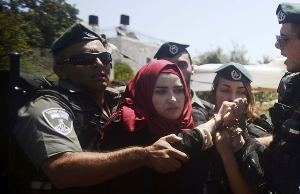 Polícial de fronteira israelense prende mulher palestina durante protesto no portão de Damasco, nesta quinta-feira (24) (Foto: Mahmoud Illean/AP)