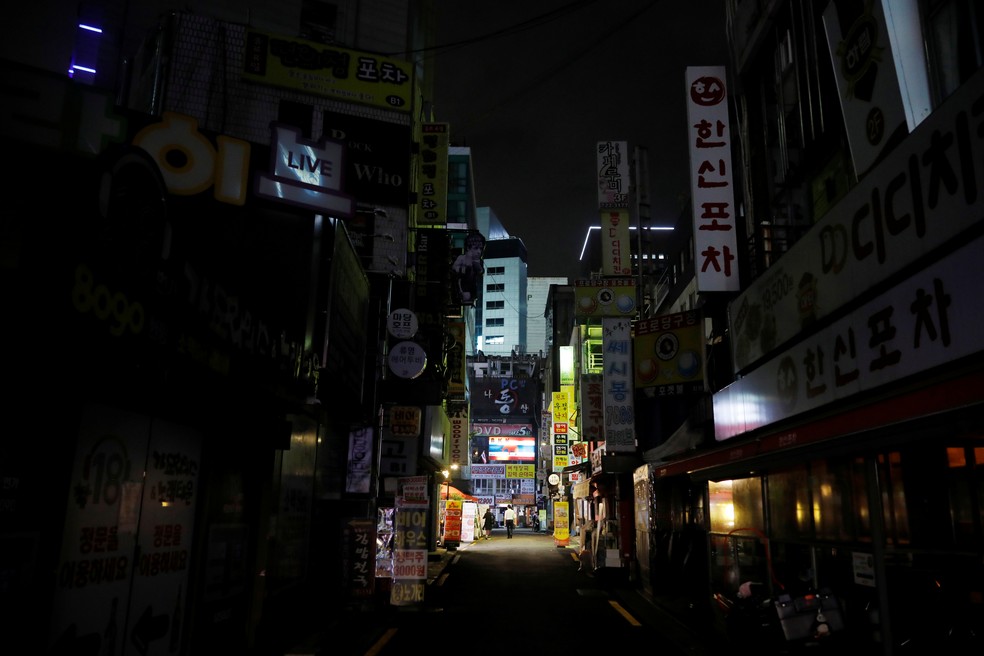 Pessoas passam por bares e restaurantes fechados após regras de distanciamento social mais rígidas para prevenir a Covid-19 em Seul, Coreia do Sul, nesta segunda-feira (31) — Foto: Kim Hong-Ji/Reuters