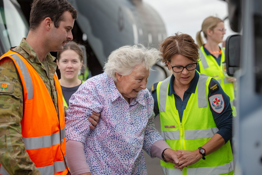 5 de janeiro - Foto divulgada pelo Departamento de Defesa Australiano mostra um soldado e uma paramédica ajudando uma senhora a embarcar em um helicóptero para evacuação de áreas afetadas pelo fogo no sudeste da Austrália — Foto: Nicole Dorrett/ADF via AP