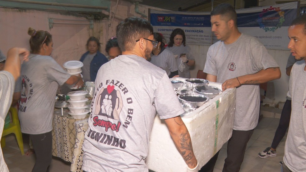 Voluntários da ONG Projeto Fazer o Bem organizam doações de alimentos para ser entregues no Centro de SP — Foto: Reprodução/TV Globo