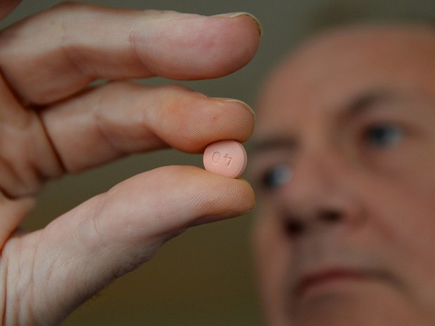 Britânico segura comprimido de estatina em Londres, em foto de 2014 (Foto: AFP / Ben Stansall)