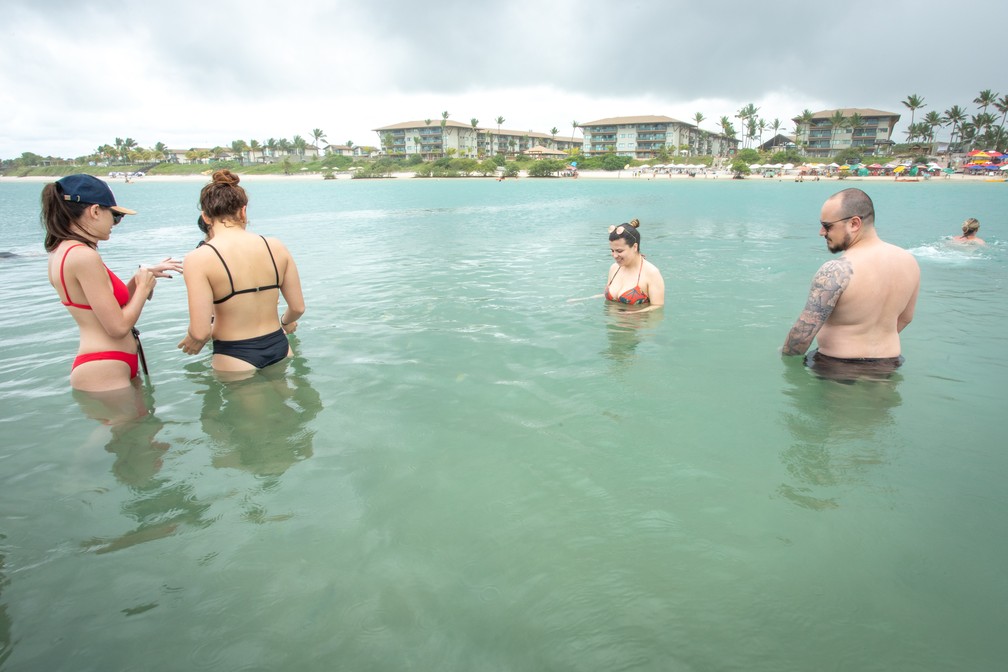 Turistas aproveitam a água morna e sem ondas da praia de Muro Alto, em Porto de Galinhas — Foto: Celso Tavares/G1