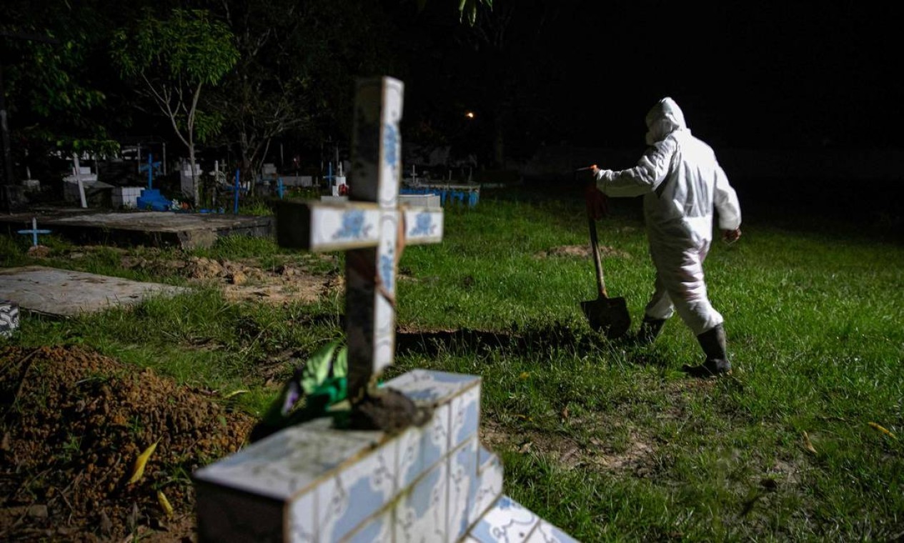 Coveiro com roupas de proteção no cemitério municipal Recanto da Paz, durante o enterro de uma vítima da COVID-19, na cidade de Breves, a sudoeste da ilha do Marajó, no Pará — Foto: TARSO SARRAF / AFP