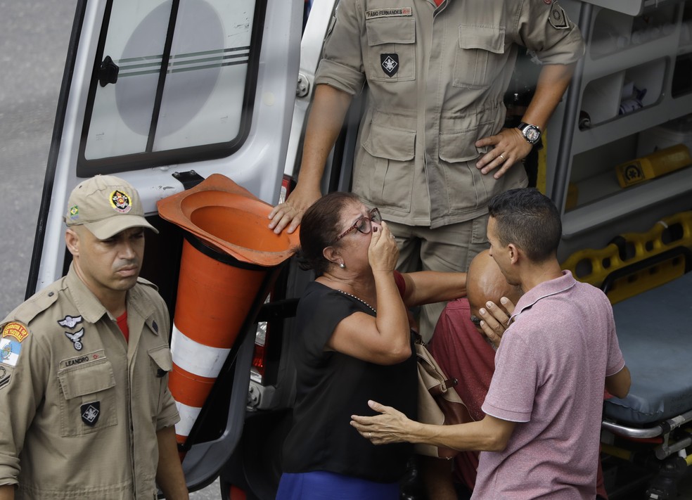 Familiares do maquinista Rodrigo Assunção durante seu resgate das ferragens do trem da Supervia que colidiu com outro na estação de São Cristóvão, Zona Norte do Rio — Foto: Leo Correa/AP