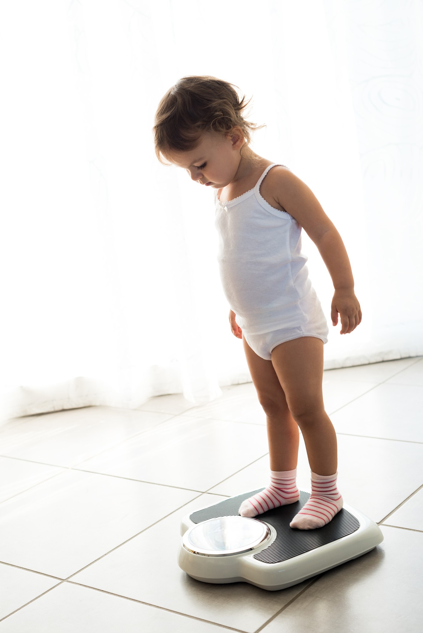 Criança sobe na balança para medir o peso (Foto: Getty Image)