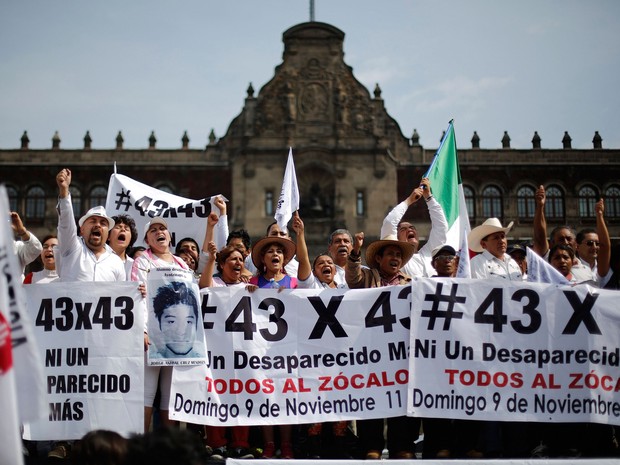 Manifestantes carregam faixas e bandeiras por mais informações sobre os estudantes desaparecidos após serem mortos, na Praça Zocalo, na Cidade do México, neste domingo (9). Os manifestantes marcharam 180 km de Iguala até a capital mexicana (Foto: Tomas Bravo/REUTERS )